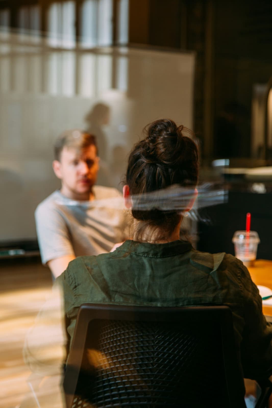 Two people talking across a desk